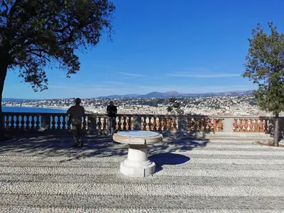 a bench sitting on the side of a walkway at Studio lumineux à 10 min de la plage in Nice