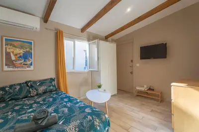 a living room with a couch and a tv at Studio lumineux à 10 min de la plage in Nice