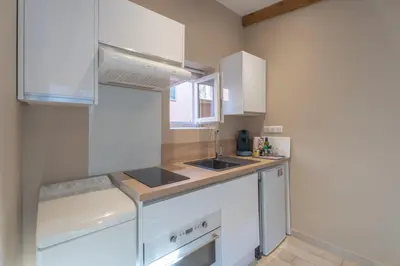 a kitchen with white cabinets and a sink at Studio lumineux à 10 min de la plage in Nice