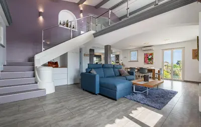 a living room with a blue couch and stairs at Lovely Home In Saint-Laurent-Du-Var in Saint-Laurent-du-Var
