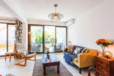 a living room with a blue couch and a chair at L'ANGE GARDIEN AP4269 by Riviera Holiday Homes in Villefranche-sur-Mer