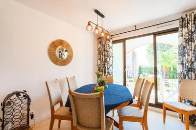 a dining room with a blue table and chairs at L'ANGE GARDIEN AP4269 by Riviera Holiday Homes in Villefranche-sur-Mer