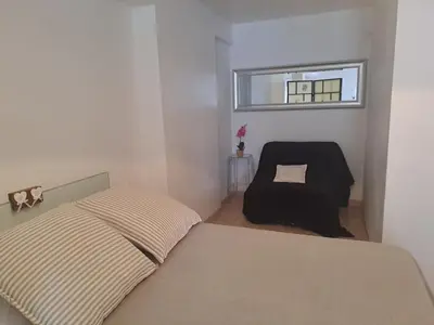 a small bedroom with a bed and a chair at Loft 2 in La Trinité
