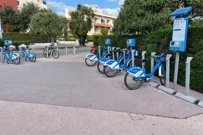 a row of blue bikes parked in a parking lot at Le Pied Dans L'eau - Parking - Seaside - Hipprodrome in Cagnes-sur-Mer