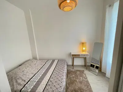 a bedroom with a bed and a table with a lamp at Nice Renting - Penchienatti - Spacious Apartment - 2 BedRooms - King Bed - View Heart of Nice in Nice