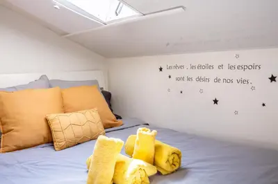 a bedroom with a bed with yellow socks on it at Homelivia, ATTIC ROOM -Mansardé sous les toits de Nice in Nice