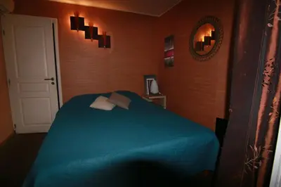 a bedroom with a blue bed and a mirror at Harmonice in Cantaron