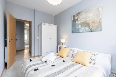 a bedroom with a large white bed with yellow pillows at Large 3 Bdr City Center in Nice