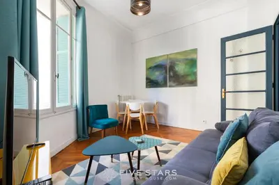a living room with a couch and a table at Suite Alsace Lorraine FSHH in Nice