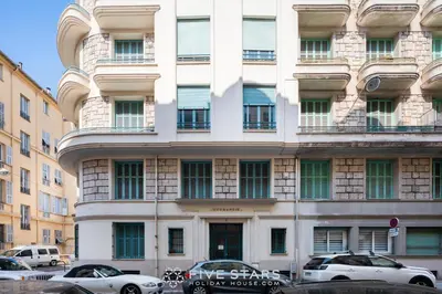 a white building with cars parked in front of it at Suite Alsace Lorraine FSHH in Nice