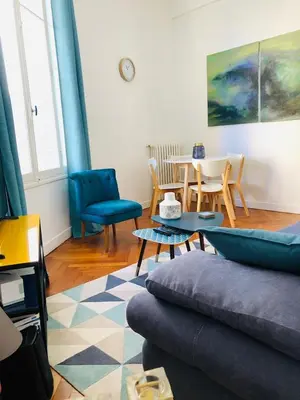 a living room with a couch and a table and chairs at Suite Alsace Lorraine FSHH in Nice