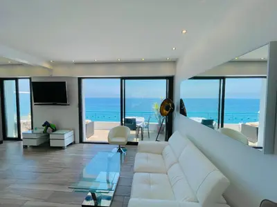 a living room with a white couch and views of the ocean at SEA VIEW TOP FLOOR - PROMENADE DES ANGLAIS in Nice
