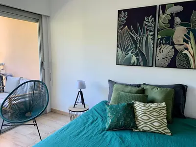 a balcony with couches and tables on a building at Appartement en résidence avec piscine in Nice