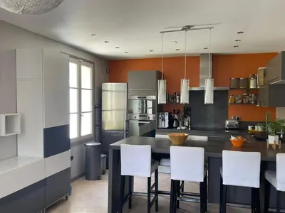 a kitchen with a table and white chairs at Appt avec jardin et clim proche Arènes de Cimiez in Nice