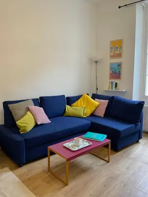 a blue couch in a living room with a table at AM STUDIO NICE in Nice