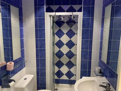 a blue tiled bathroom with a shower and a sink at Chez Chebil in rue Halevy - near the sea in Nice