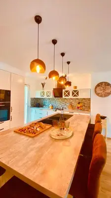 a kitchen with a large wooden table in a room at Villa Canarias in Saint-Jeannet