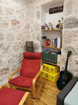 a living room with a red chair and a guitar at Our home, Cozy Apartment two minutes from the sea - Clima in Nice