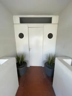 a hallway with two potted plants in front of a door at Plage Landsberg - Saint-Laurent-du-Var in Saint-Laurent-du-Var