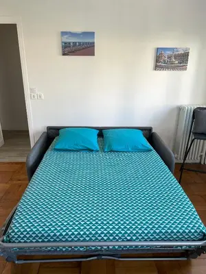 a bed with blue pillows in a room at Le 29 Promenade des Anglais - Golden Square in Nice