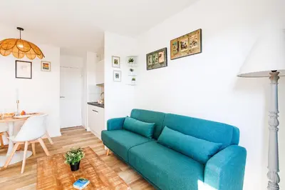 a living room with a blue couch and a table at L'ANGE GARDIEN III AP4293 By Riviera Holiday Homes in Villefranche-sur-Mer