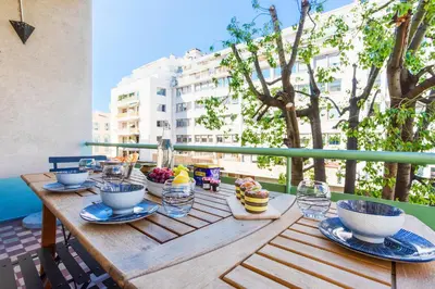 a wooden table with bowls of food on a balcony at LE TIVOLI II AP4282 By Riviera Holiday Homes in Nice