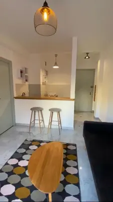 a living room with a table and a kitchen at Appartement entier. Nice Riquier in Nice
