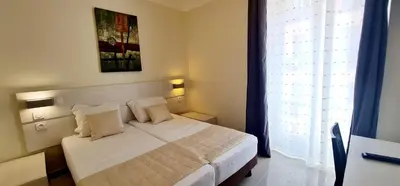 a bedroom with a white bed and a window at ESPERANCE HOTEL in Nice