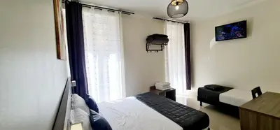 a small bedroom with a bed and a window at ESPERANCE HOTEL in Nice