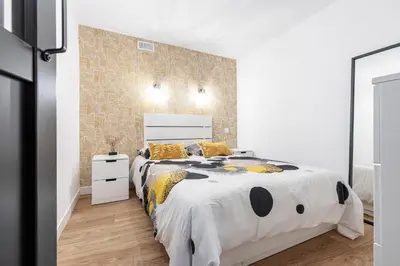 a white bedroom with a large bed with yellow pillows at Loft Magnan - PARKING - idéal couples -BEACH -TRAM & Supermarkets - New & Confort-AC in Nice