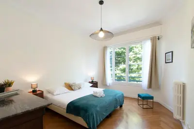 a bedroom with a bed and a large window at Maison Bianchi - Victor Hugo in Nice