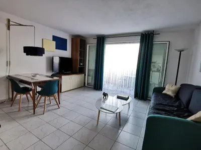a living room with a couch and a table at Studio Le Grand Bleu Fshh in Nice