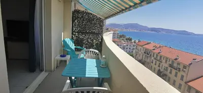 a blue table and chairs on a balcony overlooking the water at Studio Le Grand Bleu Fshh in Nice
