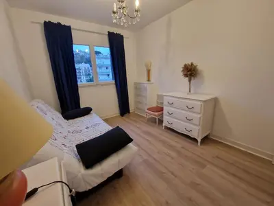 a living room with a couch and a chair at Appartement F3 traversant avec 2 terrasses et parking in Cagnes-sur-Mer