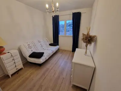 a living room with a white couch and a table at Appartement F3 traversant avec 2 terrasses et parking in Cagnes-sur-Mer