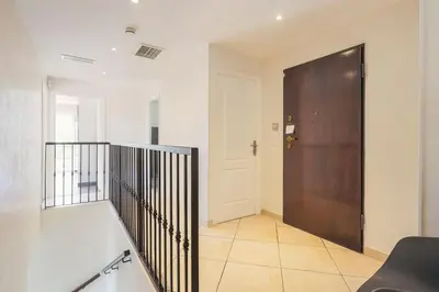 a hallway with a wooden door and a staircase at Spacieuse Villa Niçoise au calme avec piscine in Nice