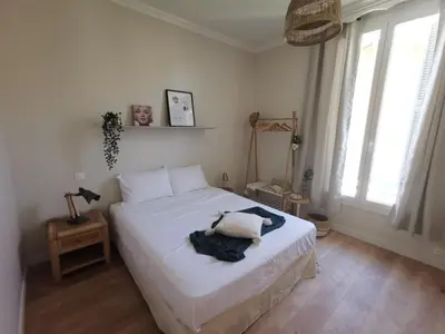 a bedroom with a bed with white sheets and windows at Appartement, 3 pièces, Villa Monte Europa in Nice