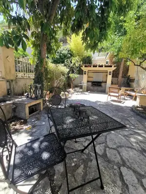 a patio with a table and chairs under a tree at Chambre privée luxueuse Villa Monte 0ropa in Nice