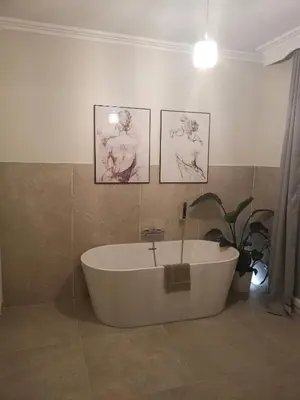 a bath tub in a bathroom with three pictures on the wall at Chambre privée luxueuse Villa Monte 0ropa in Nice