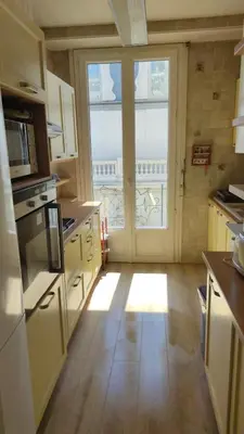 a kitchen with a large window and a kitchen with wooden floors at Le Metropole Nice Victor Hugo in Nice