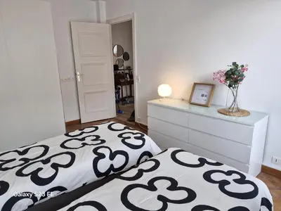 a bedroom with a black and white bed and a dresser at Le Metropole Nice Victor Hugo in Nice