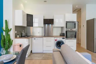 a kitchen with white cabinets and a table and chairs at Nice: hyper centre !Super appartement cosy in Nice