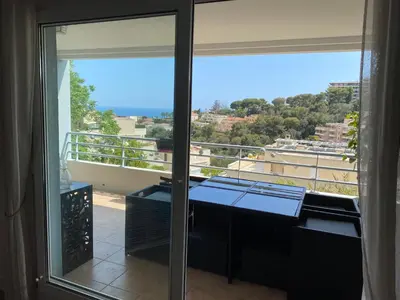 a room with a balcony with a view of the ocean at Nice Absea Fabron 1 in Nice
