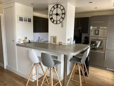 a kitchen with a counter and a clock on the wall at Nice Absea Fabron 1 in Nice