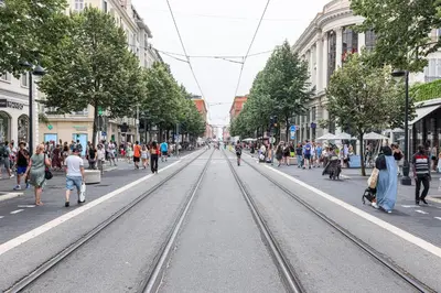 a busy city street with people walking and tram tracks at Plage et Shopping ! Appartement au cœur de Nice ! in Nice