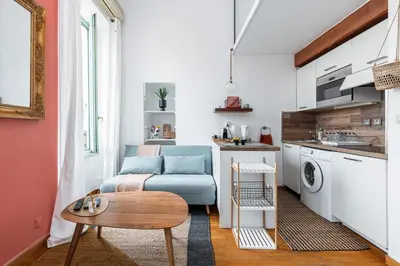 a living room with a blue couch and a table at Plage et Shopping ! Appartement au cœur de Nice ! in Nice