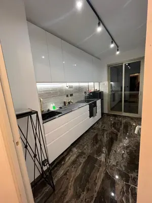 a kitchen with white cabinets and a marble floor at LE BAHIA in Nice