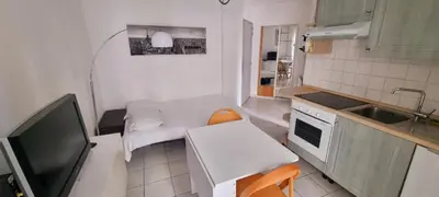 a small kitchen with a table and a television at Nice Studio With View Near Beach in Nice