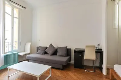 a living room with a couch and a table at Appartement Lamartinesque - Welkeys in Nice