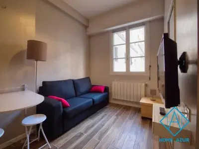 a living room with a blue couch and a tv at Port de Nice- Résidence Neptune- Superbe studio! in Nice